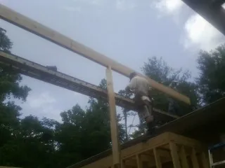 Carpenter setting a ridge beam over a new addition frame — Ice Dam Removal by Roofing Brothers in Mayview