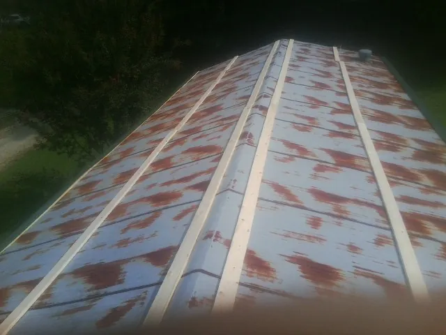 Rusted metal roof panels with new wood purlins before replacement — Storm Damage Roof Repair in Mayview by Roofing Brothers
